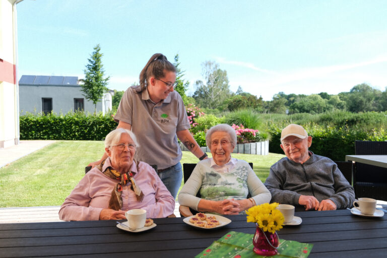 Pflegefachkraft bei der Arbeit mit Bewohnern einer Senioren Wohngemeinschaft